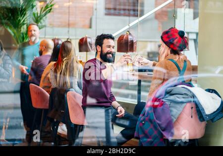 Gli amici si incontrano in un bar alla moda, coppia di occhiali da clinking Foto Stock