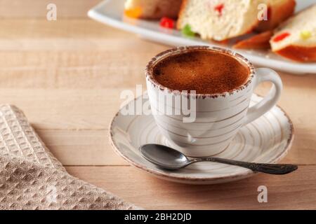 Tazza di caffè fresco aromatico con torte fatte in casa su un tavolo di legno Foto Stock