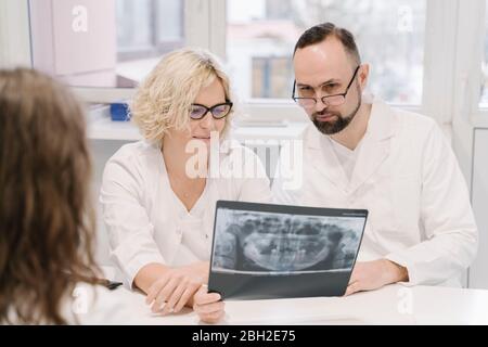 I dentisti parlano dei risultati dei raggi X per il paziente Foto Stock