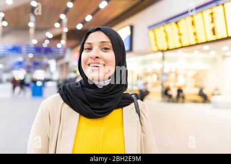 Ritratto di giovane donna sorridente che indossa hijab alla stazione ferroviaria Foto Stock