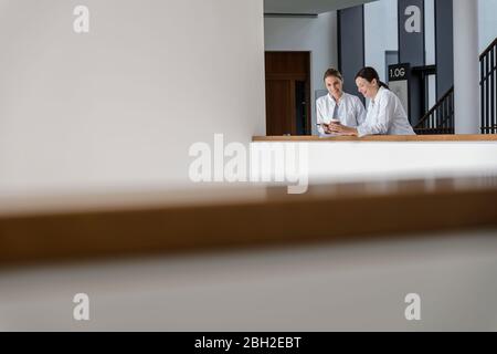 Due dottori donne che si sono interrompute e parlano in ospedale Foto Stock