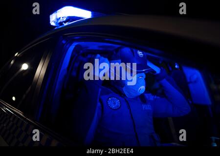 Poliziotto in missione di emergenza, mettendo sulla maschera facciale Foto Stock