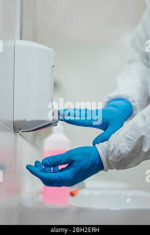 Pulizia personale desinfezione ospedale contro virus scandaloso, indossare indumenti protettivi, primo piano Foto Stock