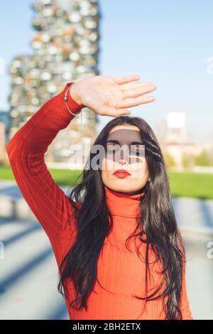 Ombra della mano sul pensieroso volto di donna durante la giornata di sole Foto Stock