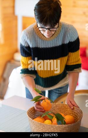 Donna con cesto di arance in cabina di legno Foto Stock