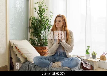 Giovane donna con tazza da caffè a casa Foto Stock