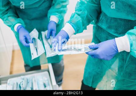 Due medici che prendono strumenti sterili formano l'armadietto Foto Stock