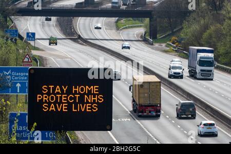 Castlecary, Scozia, Regno Unito. 23 aprile 2020. Cartello di avvertimento sull'autostrada M80 che consiglia agli automobilisti di rimanere a casa per proteggere l'NHS durante il blocco dei coronavirus nel Regno Unito. I volumi di traffico in autostrada rimangono molto bassi. Iain Masterton/Alamy Live News Foto Stock