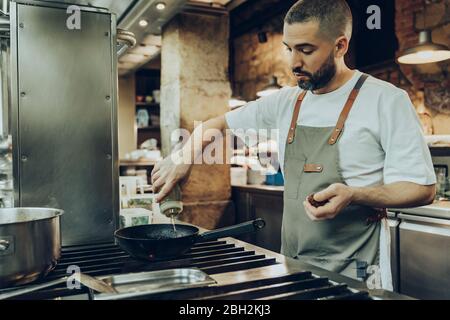Lo chef prepara il cibo del ristorante cucina Foto Stock