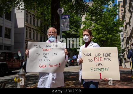 Richmond, Stati Uniti. 22 aprile 2020. Il Dr. Erich Bruhn e sua moglie Nurse Kristin Bruhn fase una controrotazione due persone alla 'riaprire Virginia' protesta a Richmond il 22 aprile 2020. Hanno esortato i partecipanti a mettere in campo procedure raccomandate dagli operatori sanitari per la loro sicurezza e la sicurezza del pubblico. (Foto di Matthew Rodier/Sipa USA) Credit: Sipa USA/Alamy Live News Foto Stock