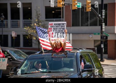 Richmond, Stati Uniti. 22 aprile 2020. Una donna tiene un segno che dice varie teorie di complotto creduto dai seguaci di QAnon dal tetto di un automobile alla protesta 'riaprire Virginia 'a Richmond il 22 aprile 2020. Tre centri Percenters sono un movimento che sostiene i diritti costituzionali e prende il nome dalla convinzione che solo il tre per cento dell'America ha preso le armi contro gli inglesi durante la guerra rivoluzionaria. (Foto di Matthew Rodier/Sipa USA) Credit: Sipa USA/Alamy Live News Foto Stock