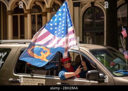 Richmond, Stati Uniti. 22 aprile 2020. Una donna fa ondare una bandiera americana adattata per riflettere QAnon fuori dalla finestra di un'auto alla protesta 'riaprire Virginia' a Richmond il 22 aprile 2020. Tre centri Percenters sono un movimento che sostiene i diritti costituzionali e prende il nome dalla convinzione che solo il tre per cento dell'America ha preso le armi contro gli inglesi durante la guerra rivoluzionaria. (Foto di Matthew Rodier/Sipa USA) Credit: Sipa USA/Alamy Live News Foto Stock