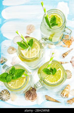Cocktail con limone, menta e ghiaccio. Decorazione estiva di conchiglie di mare limonata Foto Stock