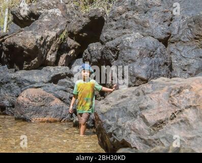 I ragazzi stavano giocando sulle rocce e godetevi la Chok Kra-Din cascate a Kanchanaburi in Thailandia Foto Stock