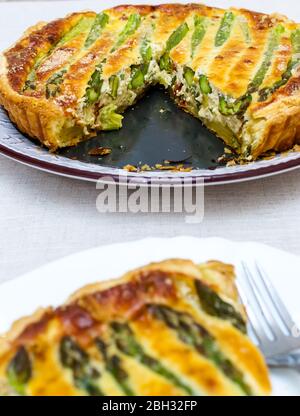 Crostata con asparagi verdi e formaggio tostato in tavola Foto Stock