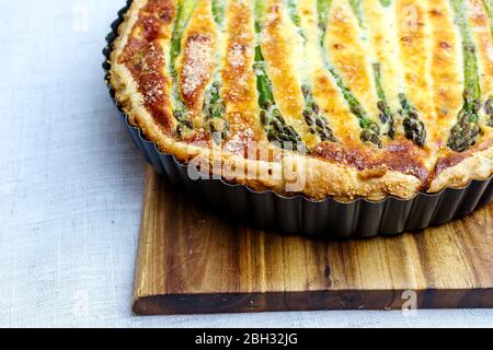 Crostata con asparagi verdi e formaggio tostato in tavola Foto Stock