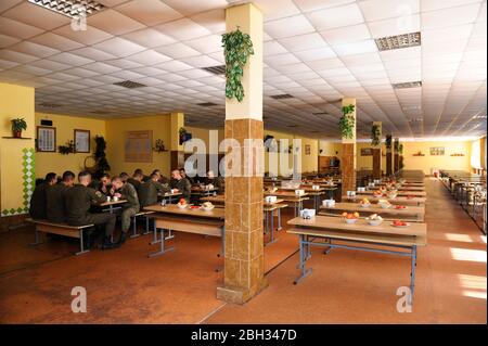 In corrispondenza di un pasticcio hall: soldati seduti al set-tabelle e mangiare. Novo-Petrivtsi base militare, Ucraina. Novembre 12, 2018 Foto Stock