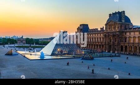 Un cielo colorato al tramonto sul cortile del Palazzo del Louvre e della Piramide di vetro, Parigi Foto Stock