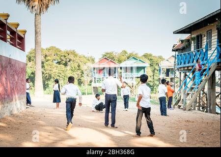 I bambini cambogiani giocano fuori dalla scuola locale nel villaggio galleggiante di Tonle SAP, Kampong Phluk, Siem Reap Province, Cambogia. Foto Stock