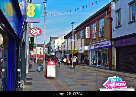 Una vista dei negozi lungo Adare Street, una delle principali aree dello shopping di Bridgend. Foto Stock