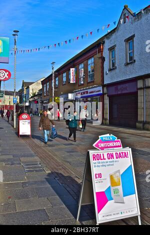 Una vista dei negozi lungo Adare Street, una delle principali aree dello shopping di Bridgend. Foto Stock