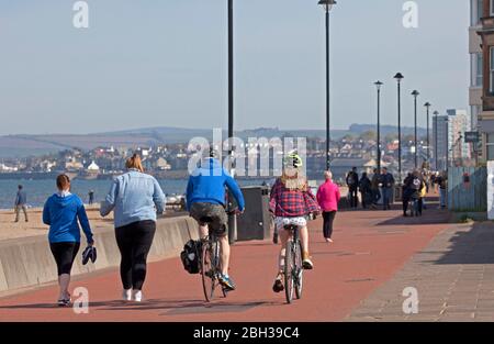 Portobello, Edimburgo, Scozia, Regno Unito. 23 aprile 2020. Pomeriggio soleggiato ma ventilato. Più persone locali si avventurano verso il mare forse incoraggiati dal sole a svolgere il loro esercizio quotidiano permesso, ancora quasi tanti ciclisti come i pedoni sulla Promenade. Foto Stock