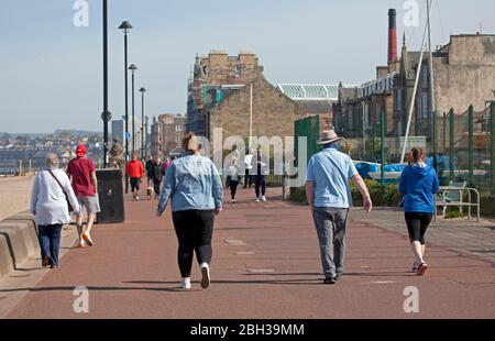 Portobello, Edimburgo, Scozia, Regno Unito. 23 aprile 2020. Pomeriggio soleggiato ma ventilato. Più persone locali si avventurano verso il mare forse incoraggiati dal sole a svolgere il loro esercizio quotidiano permesso, ancora quasi tanti ciclisti come i pedoni sulla Promenade. Foto Stock