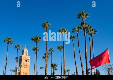 Moschea di Koutoubia e palme con la bandiera marocchina a Marrakech Marocco Foto Stock