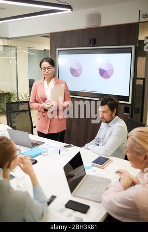 Gruppo di persone che lavorano seduti alla presentazione aziendale e che discutono nuove idee nella sala del consiglio di amministrazione dell'ufficio Foto Stock