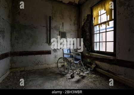 Sedia a rotelle in un ospedale abbandonato Foto Stock