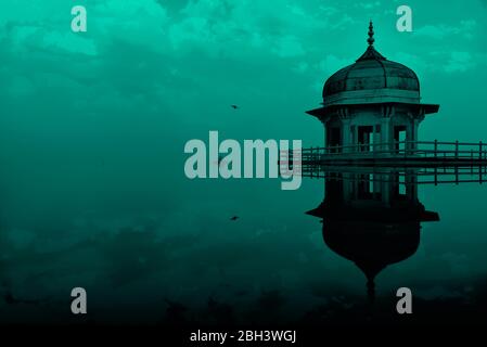 Manipolazione digitale immagine concettuale della torre Jasmine, nel forte di Agra, che appare parzialmente sommersa in acqua con un bel cielo di sera. Foto Stock