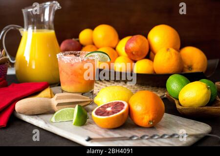 Una bevanda mista di tequila si siede su un tagliere dopo essere stata fatta con frutta fresca spremuta. Foto Stock