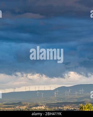 Vista a distanza di un parco eolico in un pomeriggio di primavera tempestoso Foto Stock