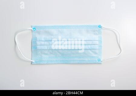 Maschera medica di protezione corona su sfondo bianco. Maschera facciale di protezione contro l'inquinamento, virus, influenza. Foto Stock