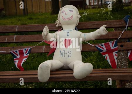 Un manichino con 'i love NHS' siede su una panchina circondata da bandiere durante il Coronavirus nostra pandemia Covid-19. Foto Stock