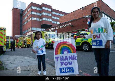 Londra, Regno Unito, 23 aprile 2020: Il personale medico e di supporto si è riunito presso la baia dell'ambulanza A&e presso il St George's Hospital di Tooting per unirsi a Clap per i nostri carers. Questa ragazza di 4 anni, Eden, aveva fatto un banner arcobaleno e lei e sua madre indossavano t-shirt fatte in casa 'grazie NHS'. Anna Watson/Alamy Live News Foto Stock