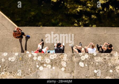 Berlino, Berlino, Germania. 23 aprile 2020. Dalla vista dall'alto, sei uomini possono essere visti godendo il sole a distanza ravvicinata in un parco di Berlino, nonostante l'attuale regolamento per contenere la diffusione del coronavirus. Le restrizioni di contatto e una distanza minima di 1.5 metri rimangono in vigore nonostante un parziale rilassamento delle restrizioni alla vita pubblica. Credit: Jan Scheunert/ZUMA Wire/Alamy Live News Foto Stock