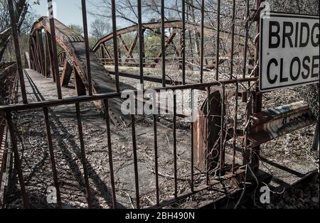 Ponte chiuso: Alberi e viti si intrecci su un ponte arrugginoso, abbandonato nella parte alta dello stato di New York. Foto Stock