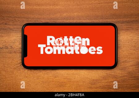 Uno smartphone con il logo Rotten Tomatoes poggia su un tavolo di legno (solo per uso editoriale). Foto Stock