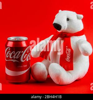 Atlanta, Georgia, USA 1 aprile 2020: Orso polare souvenir Coca-Cola seduta isolata su sfondo rosso e Coca-Cola classico rosso in alluminio lattina Foto Stock