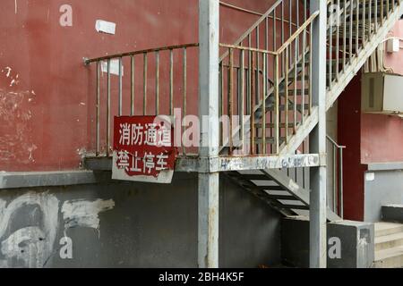 Scala di emergenza fuori da un edificio nella parte orientale di Pechino, Cina, con cartello che vieta il parcheggio per consentire l'accesso ai servizi antincendio Foto Stock