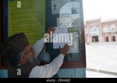 Lahore, Pakistan. 23 aprile 2020. Il professor Dr. Mufti Raghib Hussain Naeemi appendere SOP su bacheca per il comunicato di preghiera della polizia Punjab alla Moschea Darul Alom Jamia Naeemia durante un blocco nazionale imposto dal governo come misura preventiva contro il COVID-19 a Lahore (foto di Rana Sajid Hussain/Pacific Press) Credit: Pacific Press Agency/Alamy Live News Foto Stock