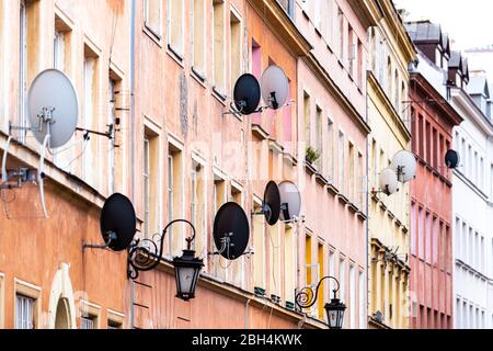 Molti piatti satellitari per internet e TV segnale di trasmissione nella piazza del mercato della città vecchia di Varsavia, Polonia con colorato appartamento architettura storica Foto Stock