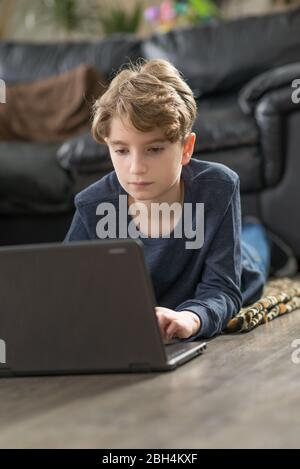 Bambino che studia da casa in mezzo alla crisi del coronavirus COVID-19 Foto Stock