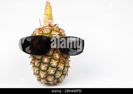 Ananas che indossa occhiali da sole su sfondo bianco Foto Stock