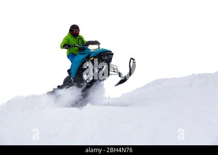 Uomo avventuroso in sella ad una motoslitta nel bianco della neve Foto Stock