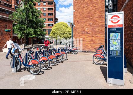 Londra, UK - 21 giugno 2018: Quartiere di Victoria con segno per molti Santander Cycles bici rosse in affitto parcheggiato alla stazione nel centro di riga da st Foto Stock