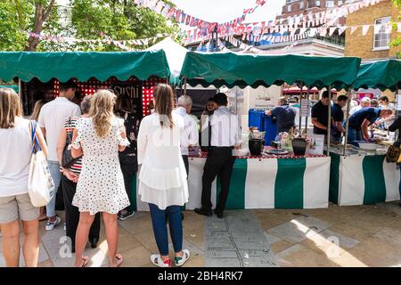 Londra, UK - 23 giugno 2018: I giovani in coda al mercato del cibo in strada nel fine settimana di Chelsea durante la giornata estiva Foto Stock