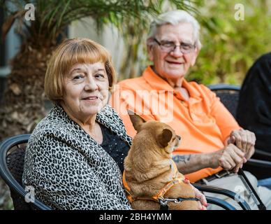 Sorridente uomo anziano e donna con il cane Foto Stock