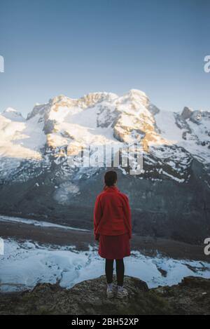 Donna in piedi sulla roccia del Ghiacciaio Gorner in Vallese, Svizzera Foto Stock